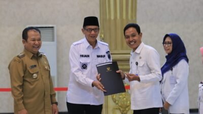 Wakil Bupati Jember, MB Firjaun Barlaman, memberikan SK kepada salah seorang PNS purna tugas. (Foto: Diskominfo Jember)