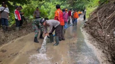 Polisi bersama warga sekitar membersihkan material longsor di Kecamatan Silo. (Foto: Humas Polres Jember - ZONA INDONESIA)