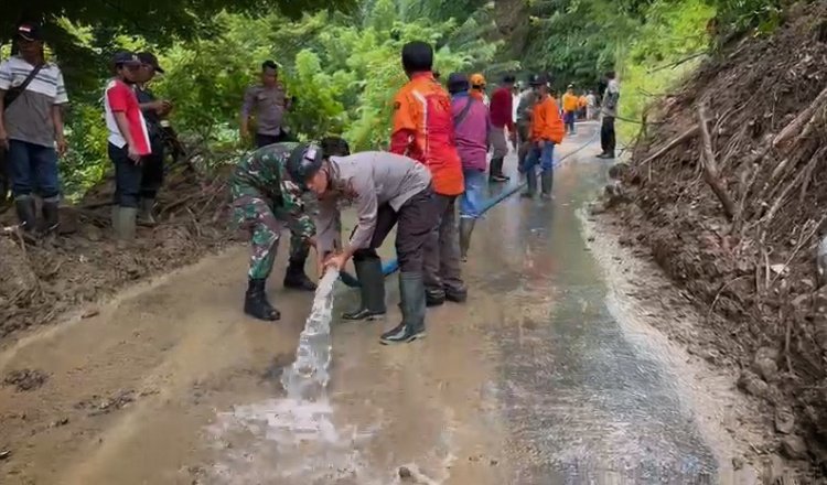 Polisi bersama warga sekitar membersihkan material longsor di Kecamatan Silo. (Foto: Humas Polres Jember - ZONA INDONESIA)