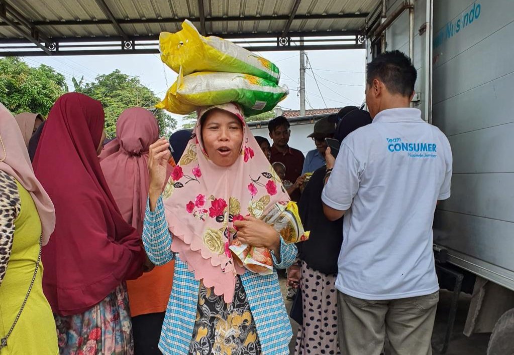 Salah seorang warga saat membawa pulang dua bungkus beras yang dibeli dalam operasi Pasar Murah. (Foto: Dikominfo Jember - ZONA INDONESIA)
