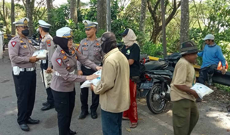 Kasatlantas Polres Jember, AKP arum Inambala, saat memberikan Bansos kepada awe-awe di Jalan Raya Gumitir.