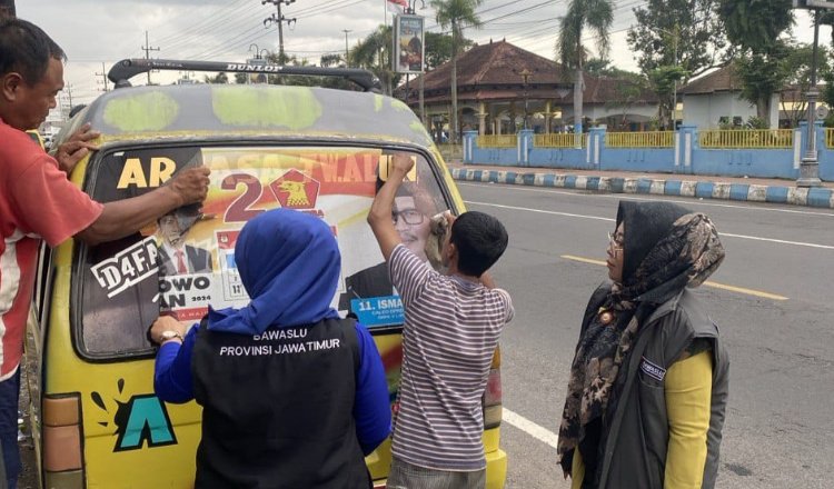 Bawaslu Jember mencopot stiker Caleg yang terpasang di Mobil Angkot. (Foto: Istimewa)