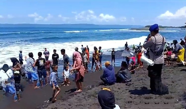 Anggota Polres Jember tengah mengimbau wisatawan untuk berhati-hati dan selalu waspada. (Foto: Humas Polres Jember)