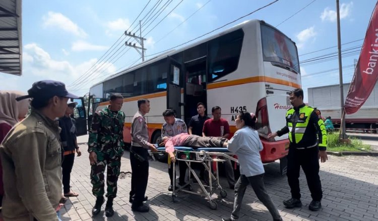 Petugas mengevakuasi pemudik asal Madiun yang pingsan di bus. (Foto: Istimewa)