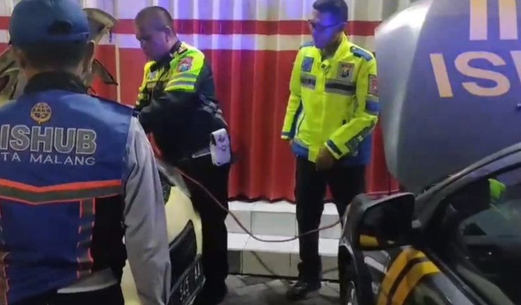Posyan UB Polresta Malang Kota membantu pengemudi saat mobilnya mogok. (Foto: Istimewa)