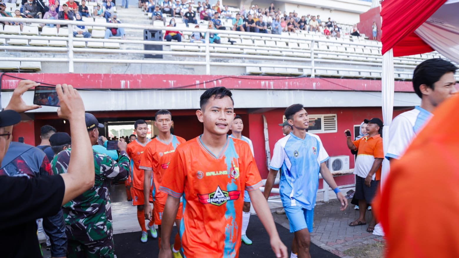Para pemain bola memasuki lapangan di stadion JSG Ajung. (Foto: Diskominfo Jember)
