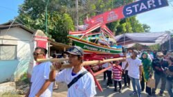 Warga mengarak miniatur perahu dalam acara kirab budaya Puger Kulon. (Foto: Istimewa)