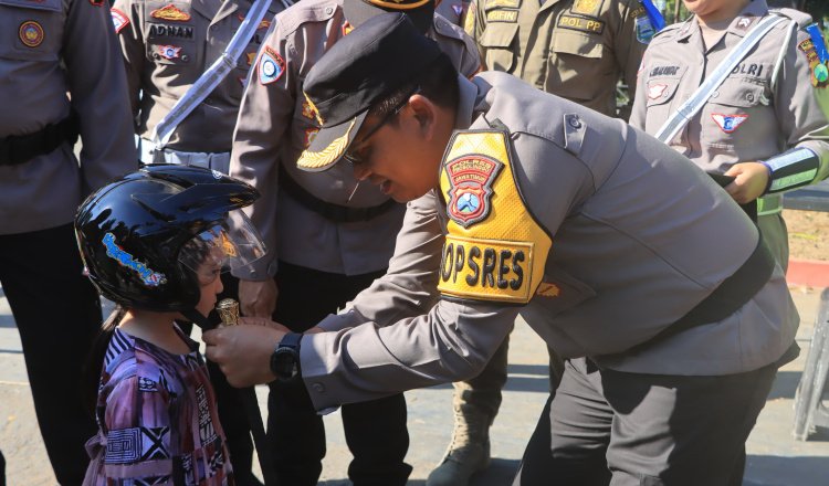 Kapolres memperbaiki helm salah seorang pengendara dalam Operasi Patuh Semeru 2024. (Foto: Humas Polres Probolinggo)