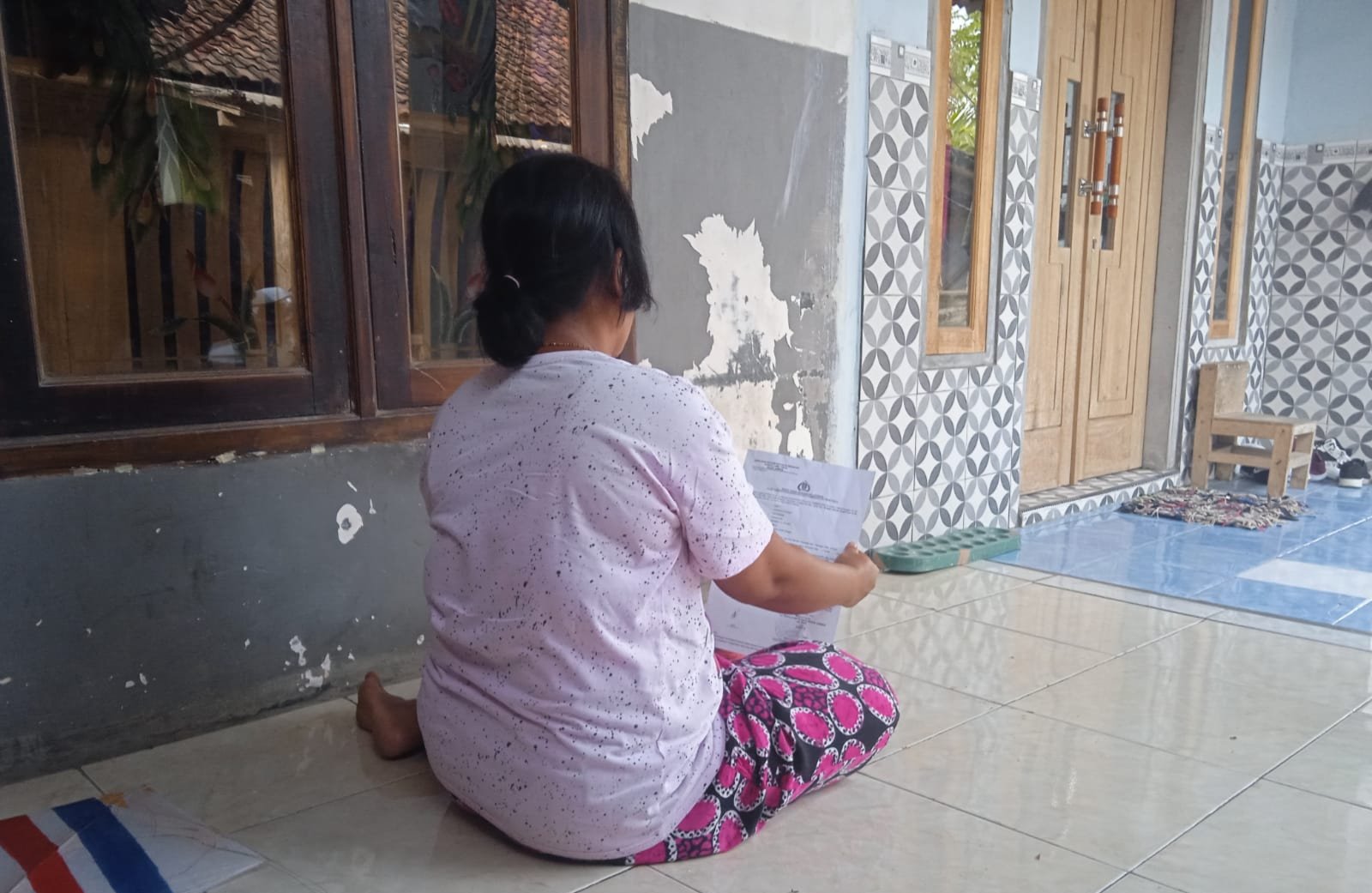 Ibu seorang difabel yang diduga menjadi korban pemerkosaan oleh iparnya menunjukkan surat tanda penerimaan laporan dari Polres Jember. (Foto: Zainul Hasan)