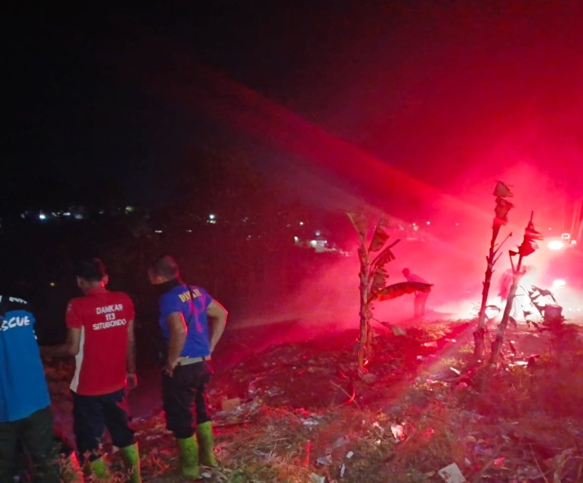 Petugas Damkar Situbondo menyemprotkan air ke lahan ilalang yang terbakar. (Foto: Humas Pusdalops BPBD Situbondo)