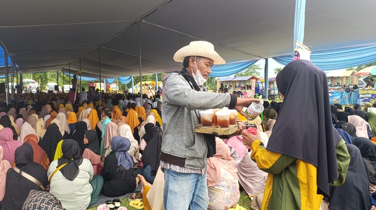 Pedagang asongan melayani pembeli dalam acara Apel Sholawat di Desa Pakis, Panti. (Foto: Zainul Hasan)