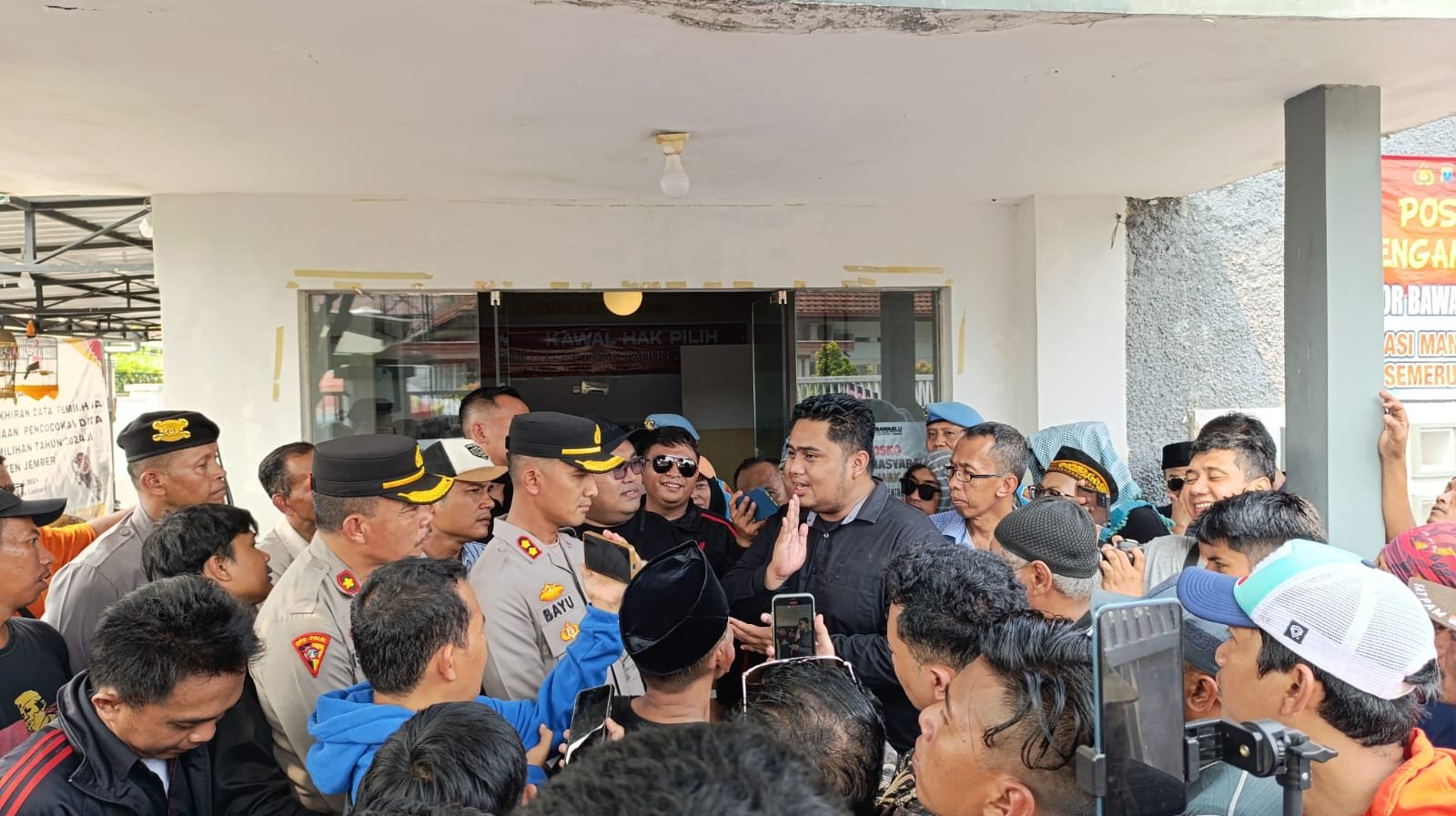 Sanda Aditya Pradana menemui warga yang berhasil masuk menjebol pagar Bawaslu Jember, Rabu (13/11/2024). (Foto: Zainul Hasan)