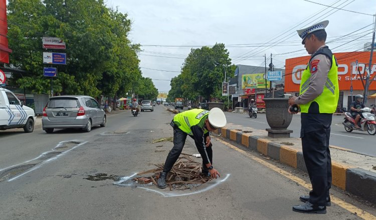Personel Satlantas Polres Situbondo menandai lubang di jalan aspal, Selasa (17/12/2024). (Foto: Humas Polres Situbondo)
