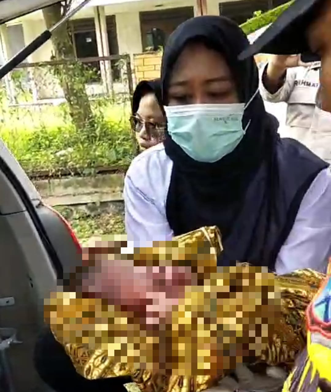 Polsek Jelbuk dan Bidan saat hendak membawa bayi yang ditemukan di sawah ke Puskesmas, Selasa (31/12/2024). (Foto: Tangkapan layar video amatir)