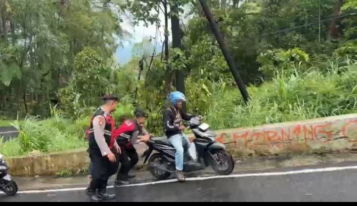 Anggota Polres Magetan membantu pengendara di tanjakan. (Foto: Istimewa)