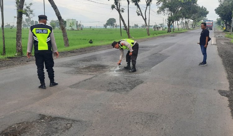 Anggota Polres Ngawi tandai jalan berlubang. (Foto: Istimewa)