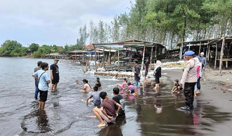 Anggota Polres Jember mengimbau wisatawan untuk tidak berenang terlalu jauh ke tengah laut. (Foto: Humas Polres Jember)