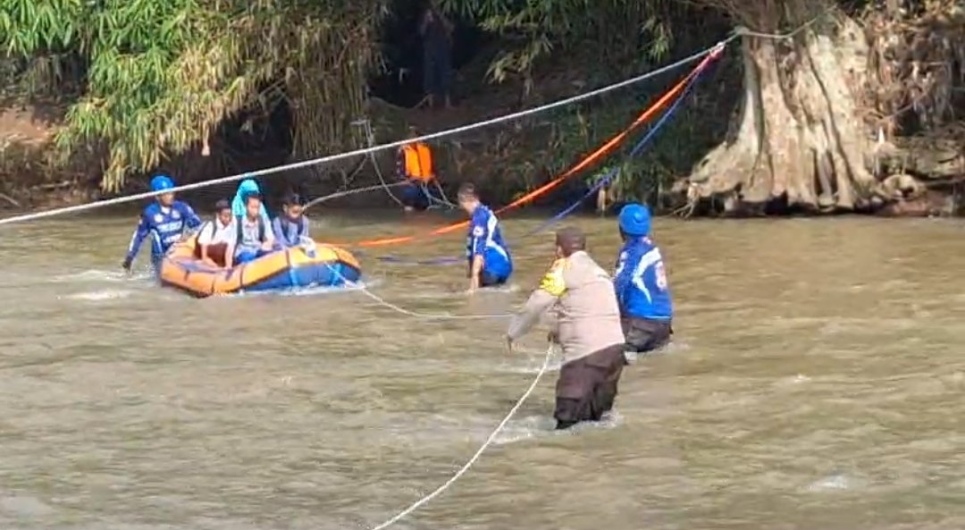 Tim Baret Rescue NasDem Jember dan polisi bergotong-royong membantu siswa menyeberang sungai menggunakan perahu karet, Rabu (15/1/2025). (Foto: Istimewa)