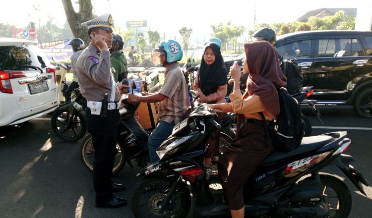 Anggota Polresta Malang Kota mengedukasi masyarakat tentang menjaga keselamatan saat berkendara. (Foto: Istimewa)