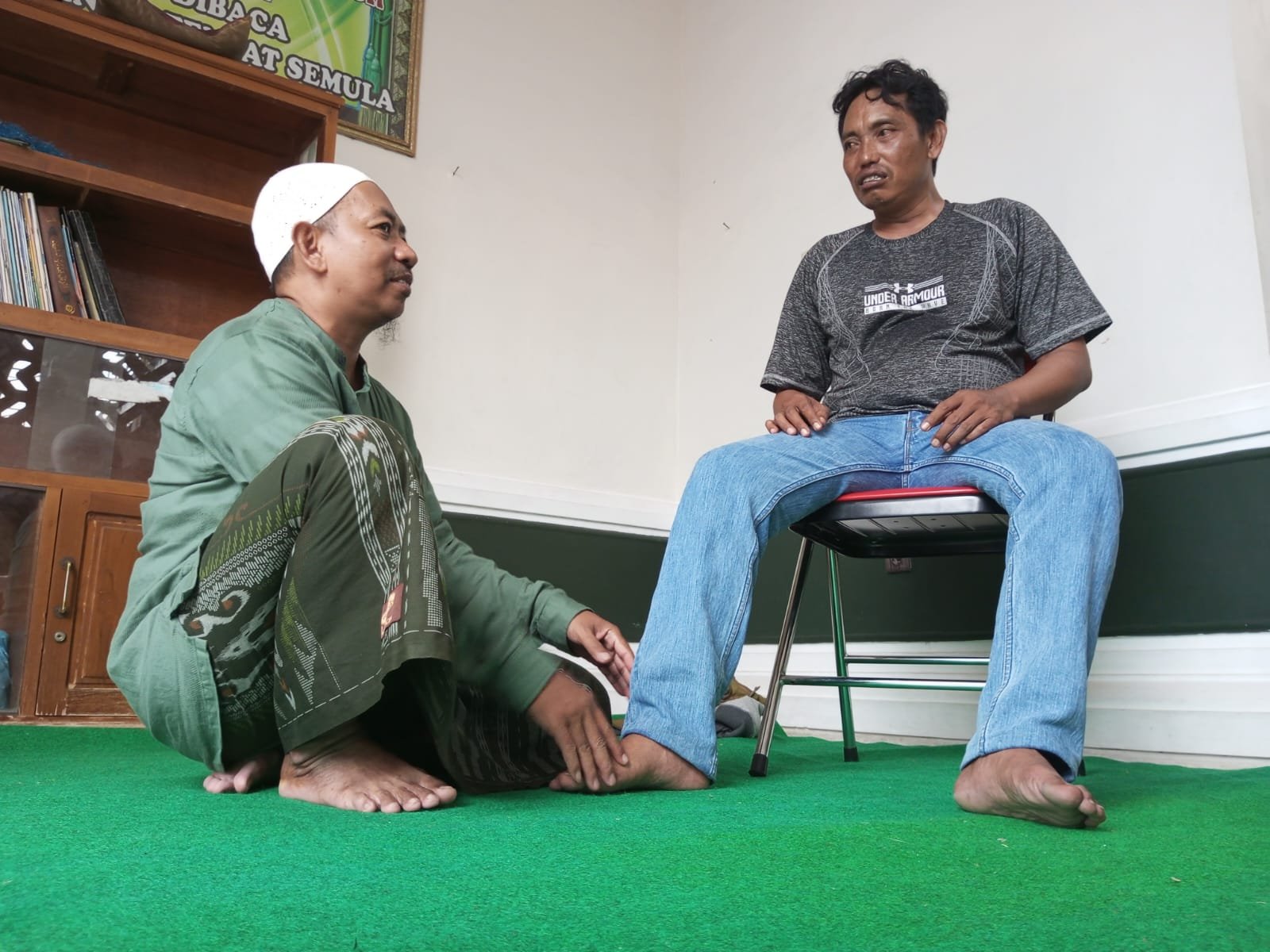 Ustad Haris saat memijat pemudik di Masjid Besar Nurul Abror Panarukan. (Foto: Fathur Rozi/zonaidonesia.co.id)