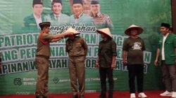 Kasatkornas Banser memasangkan topi caping kepada kader Ansor dalam acara pengukuhan patriot ketahanan pangan GP Ansor Jatim di Kabupaten Jember, Kamis (15/5/2025). (Foto: Teamwork)