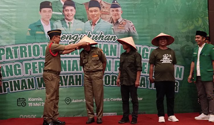 Kasatkornas Banser memasangkan topi caping kepada kader Ansor dalam acara pengukuhan patriot ketahanan pangan GP Ansor Jatim di Kabupaten Jember, Kamis (15/5/2025). (Foto: Teamwork)