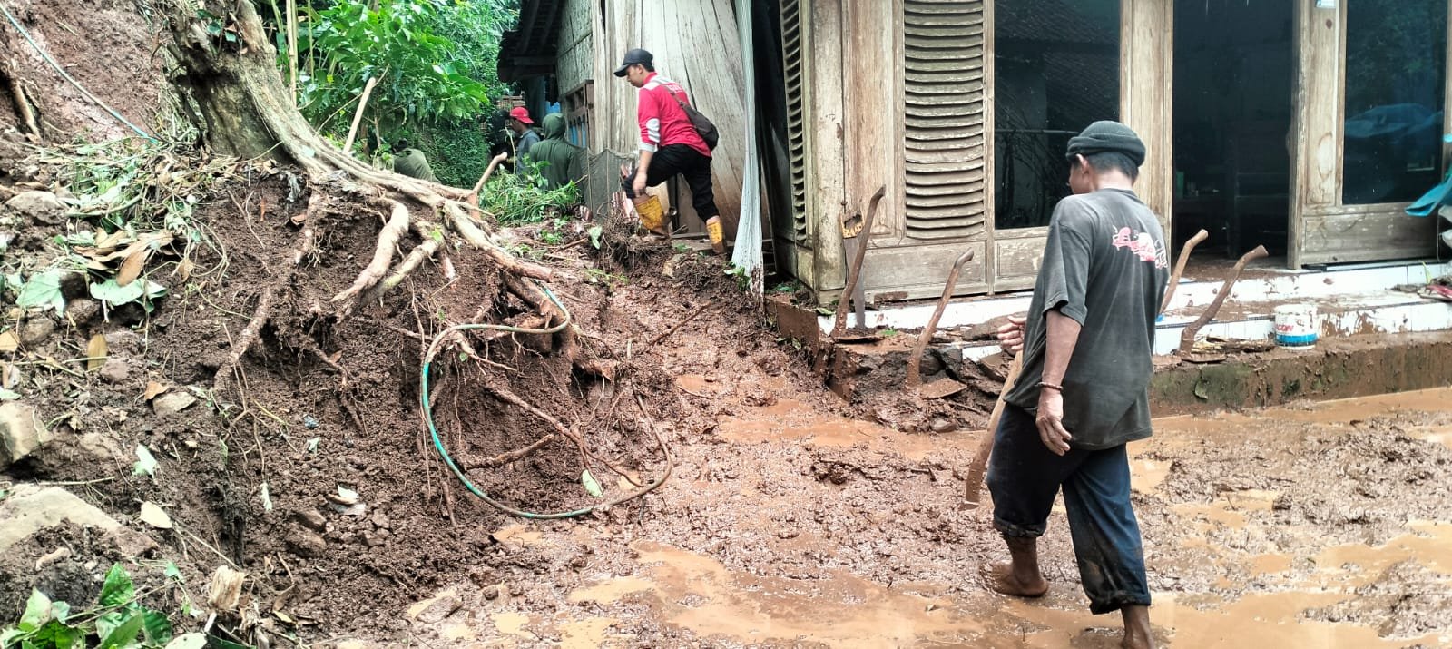Warga membersihkan material lumpur di rumah Bapak Nihar, Minggu (11/5/2025). (Foto: Pusdalops BPBD Situbondo)