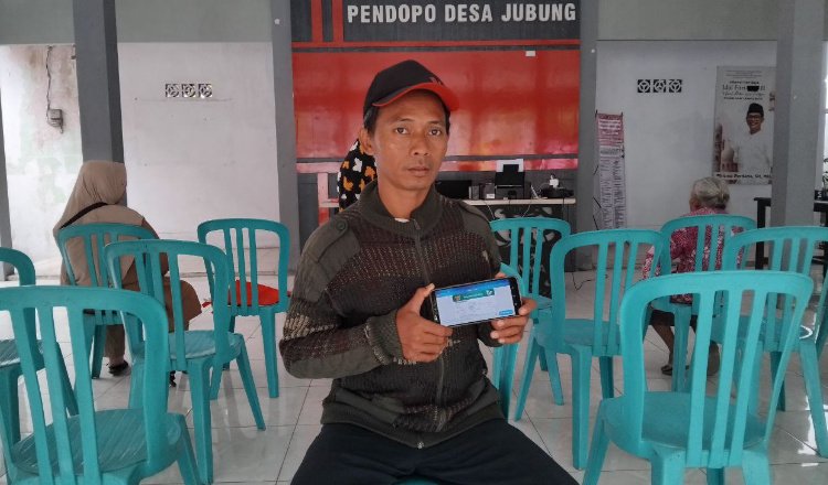 Warga Jember menunjukkan aplikasi layanan JKN Mobile. (Foto: Dok/Humas BPJS Kesehatan Cabang Jember - ZONA INDONESIA)