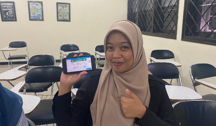 Sri Wahyuni menunjukkan aplikasi layanan JKN Mobile. (Foto: Dok/Humas BPJS Kesehatan Cabang Jember - ZONA INDONESIA)