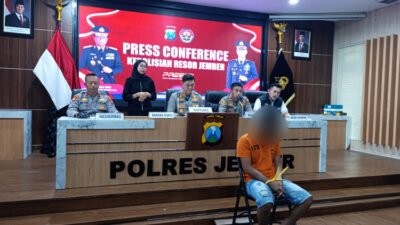 Tersangka penipuan tertunduk lesu dalam konferensi pers di Mapolres Jember, Rabu (1/10/2025). (Foto: Zainul Hasan - ZONA INDONESIA)