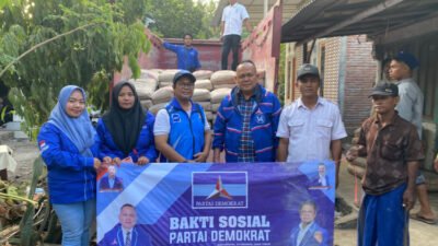 Bendahara DPD Partai Demokrat Jawa Timur, dr. Agung Mulyono, foto bersama dengan warga Sumberanyar di sela-sela penyaluran bantuan semen. (Foto: Rosi - ZONA INDONESIA)