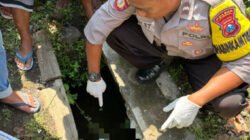 Polisi dan warga mengevakuasi mayat bayi di selokan lingkungan Darungan, Sabtu (18/10/2025). (Foto: Istimewa - ZONA INDONESIA)