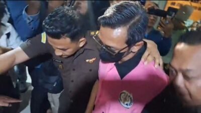 Tersangka kasus korupsi Sosraperda keluar dari Kejari Jember menuju mobil tahanan, Senin (20/10/2025) malam. (Foto: Istimewa - ZONA INDONESIA)