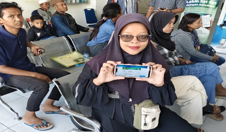 Divya Yuni Anggraeni menunjukkan layanan mobile JKN. (Foto: Dok/Diskominfo Jember)
