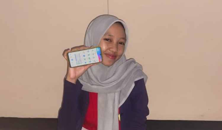 Adelia Dara Puspita menunjukkan layanan mobile JKN. (Foto: Dok/Humas BPJS Kesehatan Cabang Jember - ZONA INDONESIA)