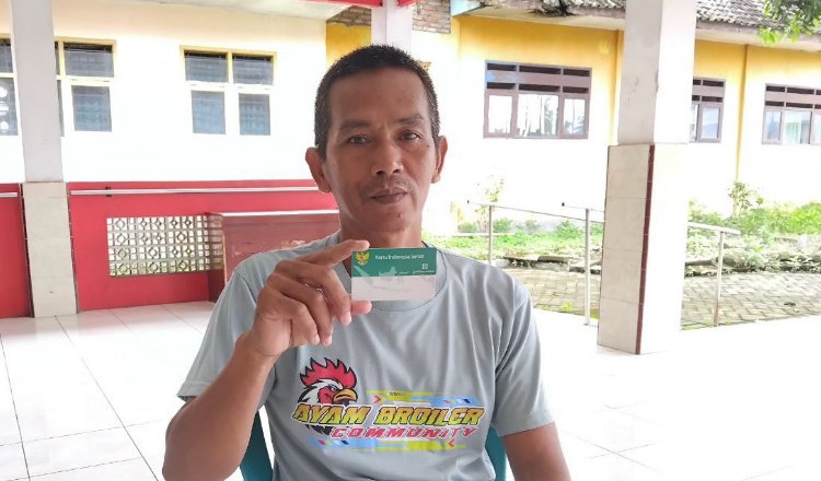 Yudi menunjukkan kartu Indonesia Sehat/BPJS Kesehatan. (Foto: Dok/Humas BPJS Kesehatan Cabang Jember)