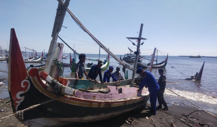 Tim gabungan mendorong perahu nelayan di pesisir pantai. (Foto: Fathur Rozi - ZONA INDONESIA)