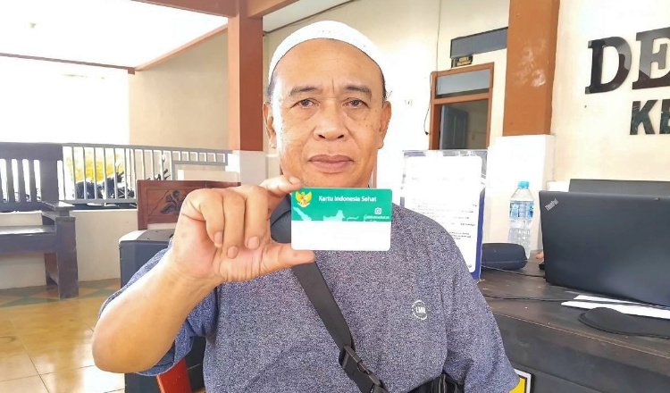 Mulyono menunjukkan layanan Mobile JKN. (Foto: Dok/Humas BPJS Kesehatan Cabang Jember)
