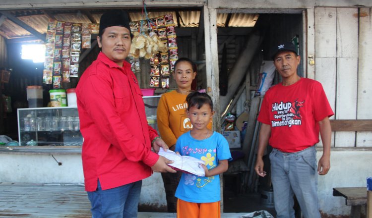 Sekretaris DPC PDI Perjuangan Situbondo, Fathor Rahman, membagikan seragam sekolah gratis untuk siswi SD yang membutuhkan. (Foto: Istimewa - ZONA INDONESIA)