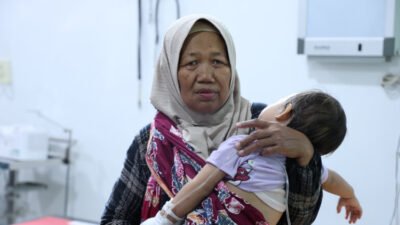 Seorang ibu menggendong anaknya yang keracunan MBG. (Foto: Dok/Diskominfo Jember - ZONA INDONESIA)